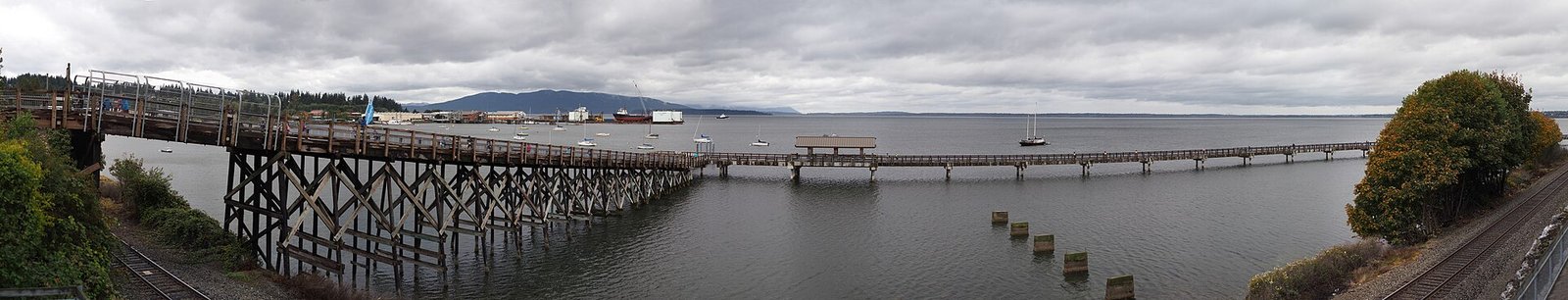 Long wooden boardwalk on pilings crossing Bellingham Bay at Taylor Dock